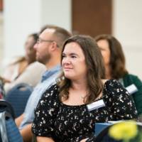 Audience members listening to speaker 6